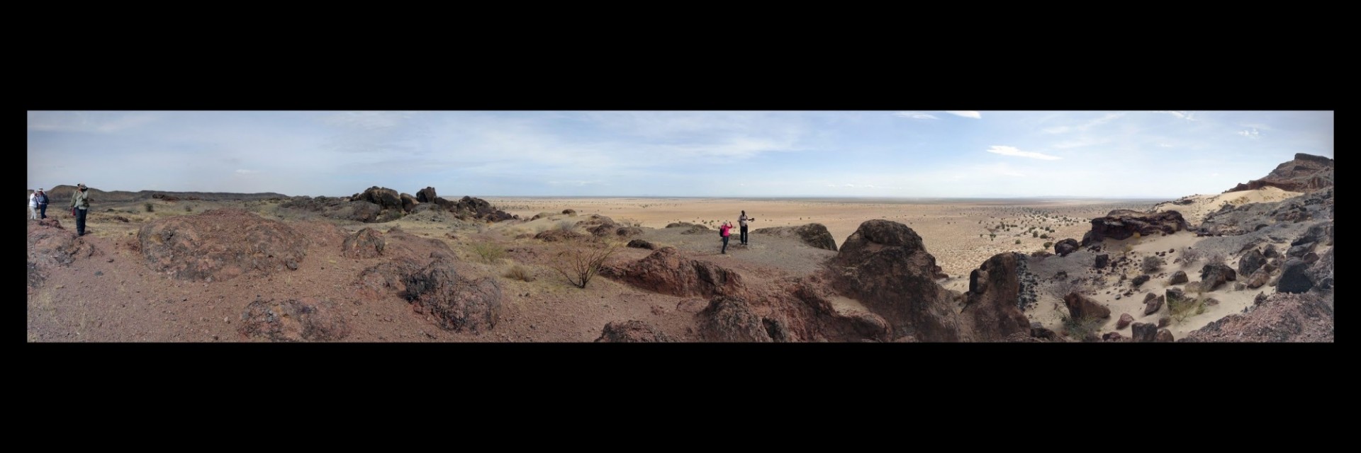 Geologists standing on basalt flows overlooking an expanse